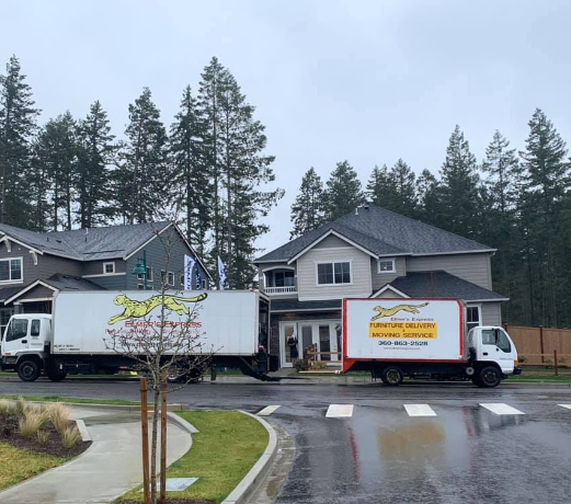 Elmer's Express moving trucks outside a home